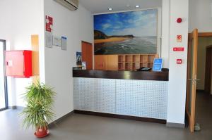 a lobby with a counter with a painting on the wall at Vicentina Hotel in Aljezur
