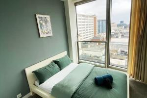 a bed in a room with a large window at Birmingham City Centre, 2 bedroom Apartment, in Birmingham