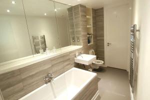 a bathroom with a tub and a sink and a toilet at Birmingham City Centre, 2 bedroom Apartment, in Birmingham