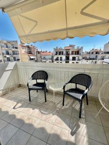 a patio with two chairs and a table and an umbrella at City1 lux apartment in Serres