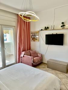 a bedroom with a bed and a flat screen tv at City lux apartment 1 in Serres