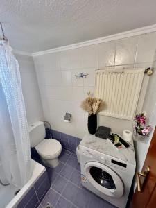 a bathroom with a washing machine and a toilet at City1 lux apartment in Serres +11 photos