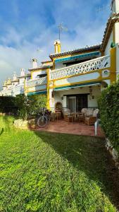 a large yellow house with a patio in front of it at Casa Costa del Sol Beach&Golf,Marbella in Sitio de Calahonda