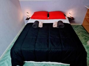 a bedroom with a bed with red pillows and slippers at LE CROSERY Clim Rando Ski Gorges Voie Verte in Thiéfosse
