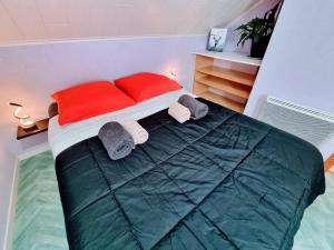 a bedroom with a bed with red pillows and towels at LE CROSERY Clim Rando Ski Gorges Voie Verte in Thiéfosse