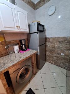 a kitchen with a refrigerator and a washing machine at appartement de nouri à marti in Martil +9 photos