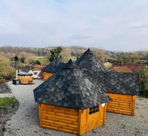 Longueil的住宿－Maison bois kota / bain nordique / proche de la mer / kota grill，一组带屋顶的木制建筑