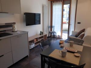 a kitchen and a living room with a table and a tv at Il Rosone in Tirano