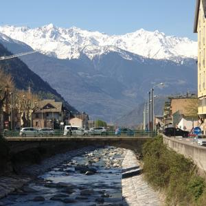 蒂拉諾的住宿－Il rosone，一座河上的桥梁,底下是积雪覆盖的群山