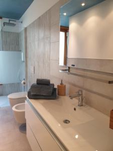 bagno con lavandino, servizi igienici e specchio di Il rosone a Tirano