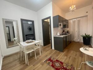 eine Küche und ein Wohnzimmer mit einem Tisch und Stühlen in der Unterkunft Dreamsrome Lux in Rom