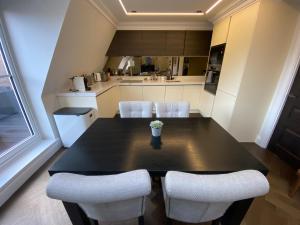 a kitchen with a black table and white chairs at Beautiful Penthouse in centre of Winchester in Winchester
