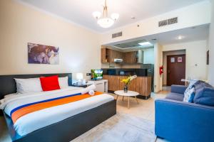 a bedroom with a large bed and a blue couch at RH- Perfect Downtown Getaway for Couple, Near Dubai Mall in Dubai