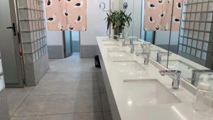 a row of sinks in a public bathroom at WeFlow Youth Hostel - Shanghai People's Square Jing'an Joy City in Shanghai