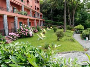 a garden in front of a building with chairs and flowers at Loggia Portofino 2 in Rapallo