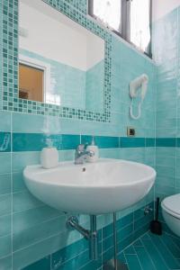 Baño de azulejos azules con lavabo y espejo en House Rene, en Agerola
