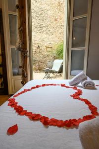 a white bed with red rose petals on it at Amourette à Sète in Sète