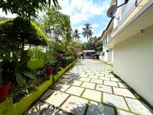 a stone walkway with plants on the side of a building at Deluxe Residency in Kalpetta