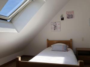 een slaapkamer met een bed op zolder bij Studios - Location de vacances Le Trécelin in Plévenon