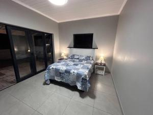 a bedroom with a bed and a flat screen tv at Saldeseas in Strandfontein