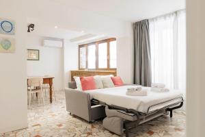 um quarto com uma cama e um sofá num quarto em Giordano Luxury Home em Florença