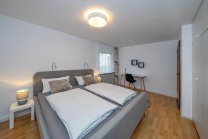 um quarto com uma cama grande e lençóis brancos em Fuchs und Hase em Illingen