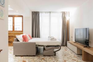 um quarto com uma cama, um sofá e uma televisão em Giordano Luxury Home em Florença