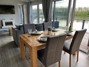 a dining room with a wooden table and chairs at Waterside Retreat Heron Lakes Nr Beverley in Beverley
