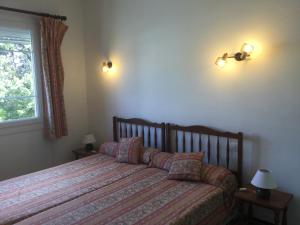 a bedroom with a bed and two lamps and a window at Villa Macoran 2 étoiles in Saint-Aygulf