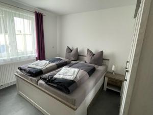 un letto con due cuscini sopra in una camera da letto di Ferienhaus Pank a Heringsdorf