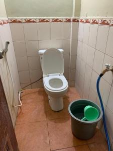 a bathroom with a toilet and a bucket at Hotel Pelangi HS in Ngabean