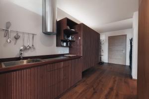 a kitchen with wooden cabinets and a sink at Apartments by Bemelmans-Post in Collalbo