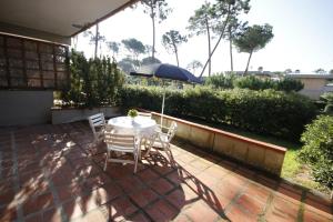a patio with a table and chairs and an umbrella at Appartamenti MareMaremma in Principina a Mare