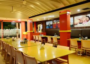 a dining room with tables and chairs in a restaurant at Hotel Tri Sea in Kanyakumari