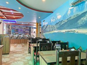 a restaurant with a mural of mountains on the wall at Hotel Readers Inn Pvt.Ltd in Kathmandu