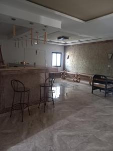 una habitación vacía con sillas y un bar en ella en VILLA BELLA VITA HAMMAMET, en Hammamet Sud