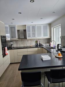 a kitchen with white cabinets and a black counter top at Montana Guest House. in Lillestrøm