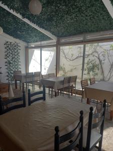 Habitación con mesas, sillas y una pared de ventanas. en VILLA BELLA VITA HAMMAMET en Hammamet Sud