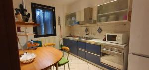 una pequeña cocina con mesa y microondas en MGC en Modena