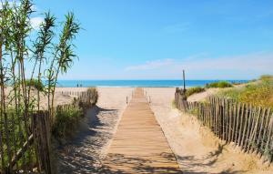 a wooden path to the beach with the ocean in the background at Stunning Home In Saint-Laurent-De-La-Cabrerisse in Saint-Laurent-de-la-Cabrerisse +16 photos
