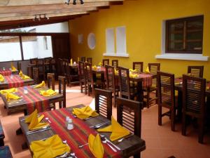 un restaurante con mesas de madera y sillas con servilletas amarillas en Hostería Hotel Cuello de Luna - Cotopaxi - Country Inn, en Lasso