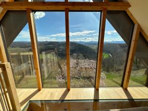 a window in a house with a view of the mountains at Winzerhaus Römerstrasse in Kitzeck im Sausal