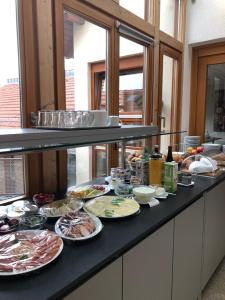 un buffet con muchos platos de comida en una barra en Gästehaus & Weingut PETH en Flörsheim-Dalsheim