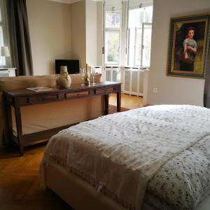 a bedroom with a table with a bed and a painting at Vila Adelaide in Brtníky