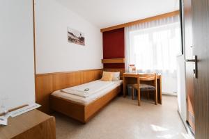 a small room with a bed and a desk at Hotel Weisses Ross in Konnersreuth