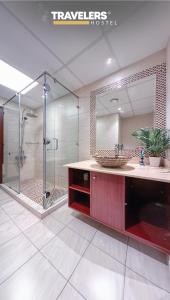 y baño con lavabo y ducha con espejo. en Travelers - Dubai Marina Hostel, en Dubái