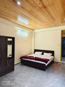 a bedroom with a bed and a wooden ceiling at MoonLight Guest House in Kasol