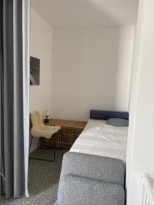 um pequeno quarto com uma cama e uma cadeira em Studio Heinrich 1 em Tutzing