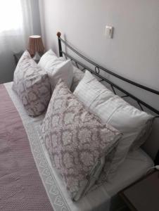Una cama con almohadas blancas y una lámpara. en BLE apartments, en Iräon