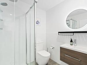 a bathroom with a toilet and a glass shower at Burrows Hutch Wanaka in Albert Town